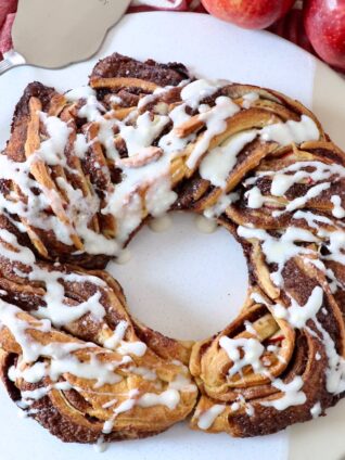 baked cinnamon roll wreath drizzled with cream cheese frosting