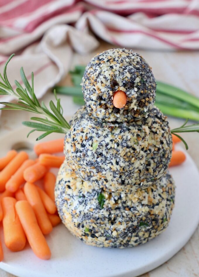 cheese ball snowman on serving tray with carrot sticks