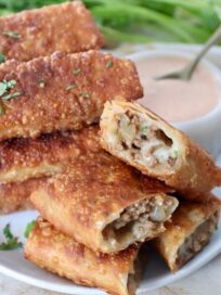 cheeseburger egg rolls cut in half, stacked up on plate