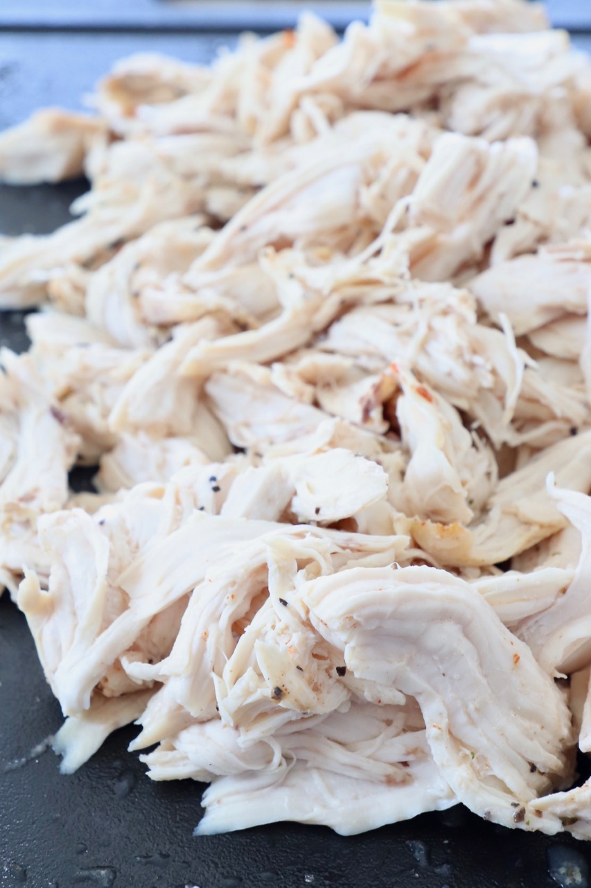 cooked, shredded chicken on cutting board
