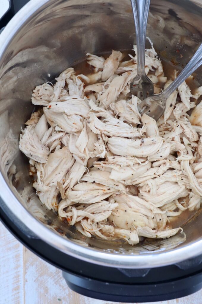 shredded chicken in Instant Pot with two forks