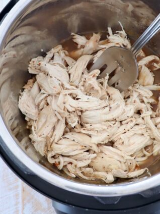 shredded chicken in instant pot with large serving fork