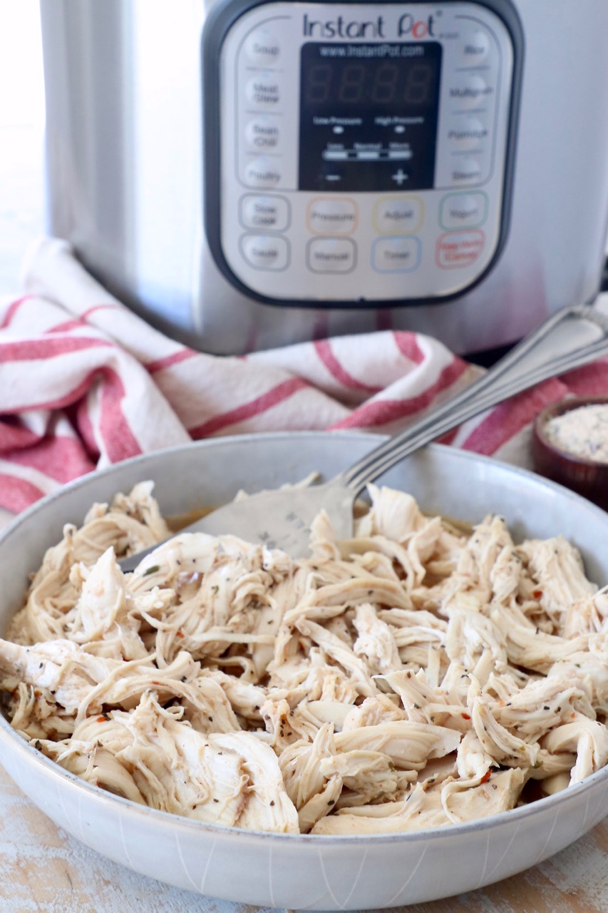 shredded chicken in bowl, sitting in front of an Instant Pot