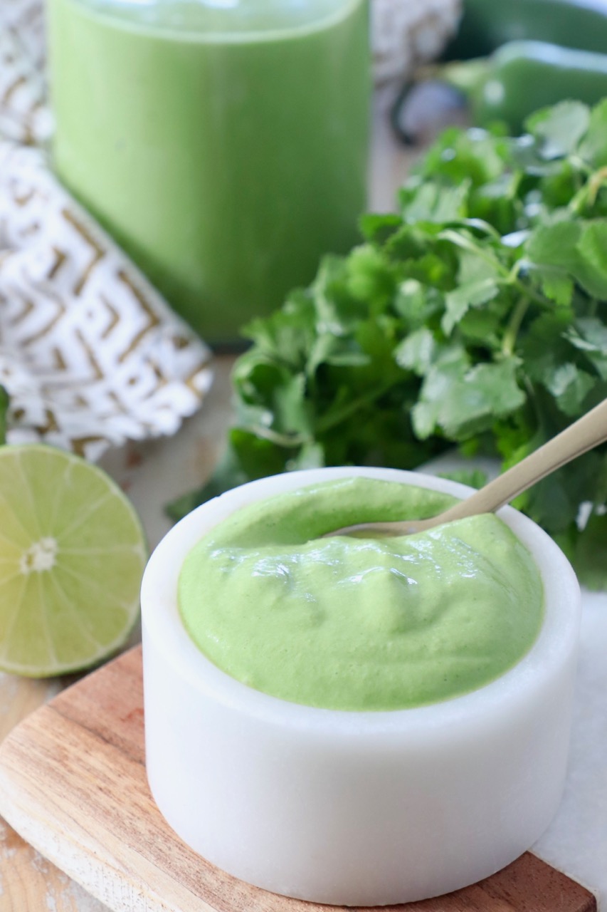 cilantro lime sauce in small white bowl with spoon