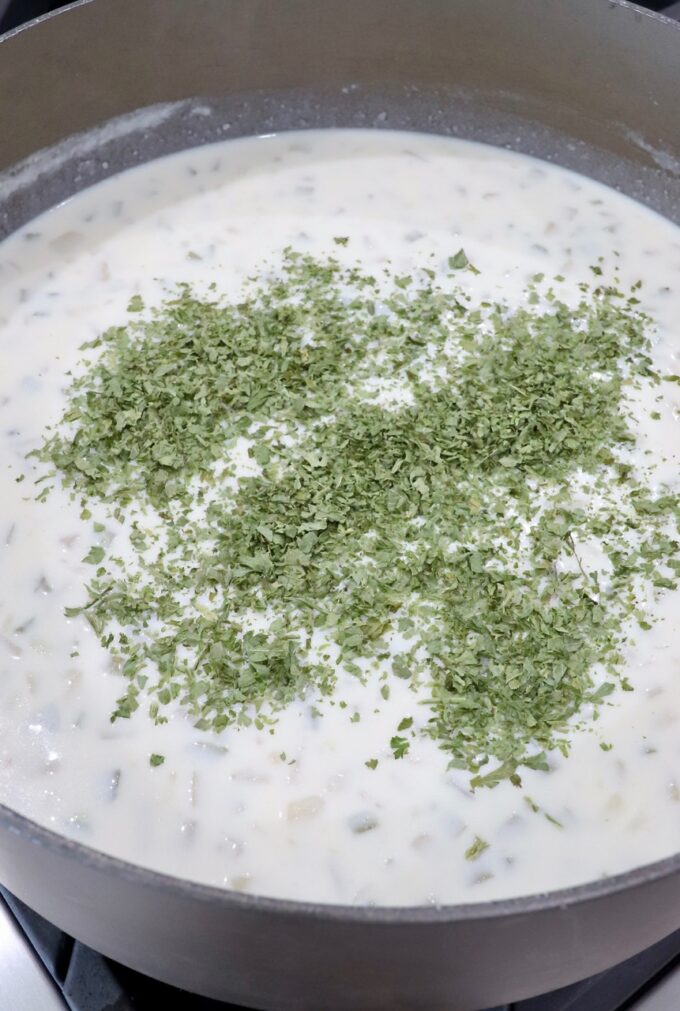 potato soup topped with dried parsley in a large pot