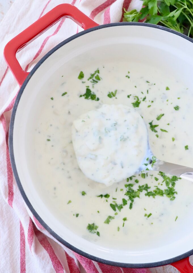 potato soup in a large pot with a ladle dipping into the soup