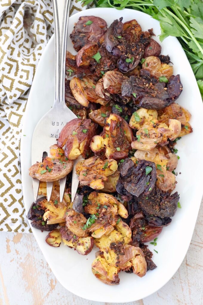 crispy smashed potatoes on plate with large serving fork