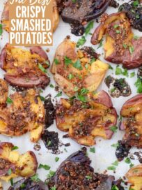 baked smashed potatoes on a parchment-lined baking sheet