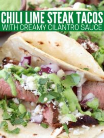 steak tacos on plate topped with cilantro sauce, cotija cheese and diced red onions