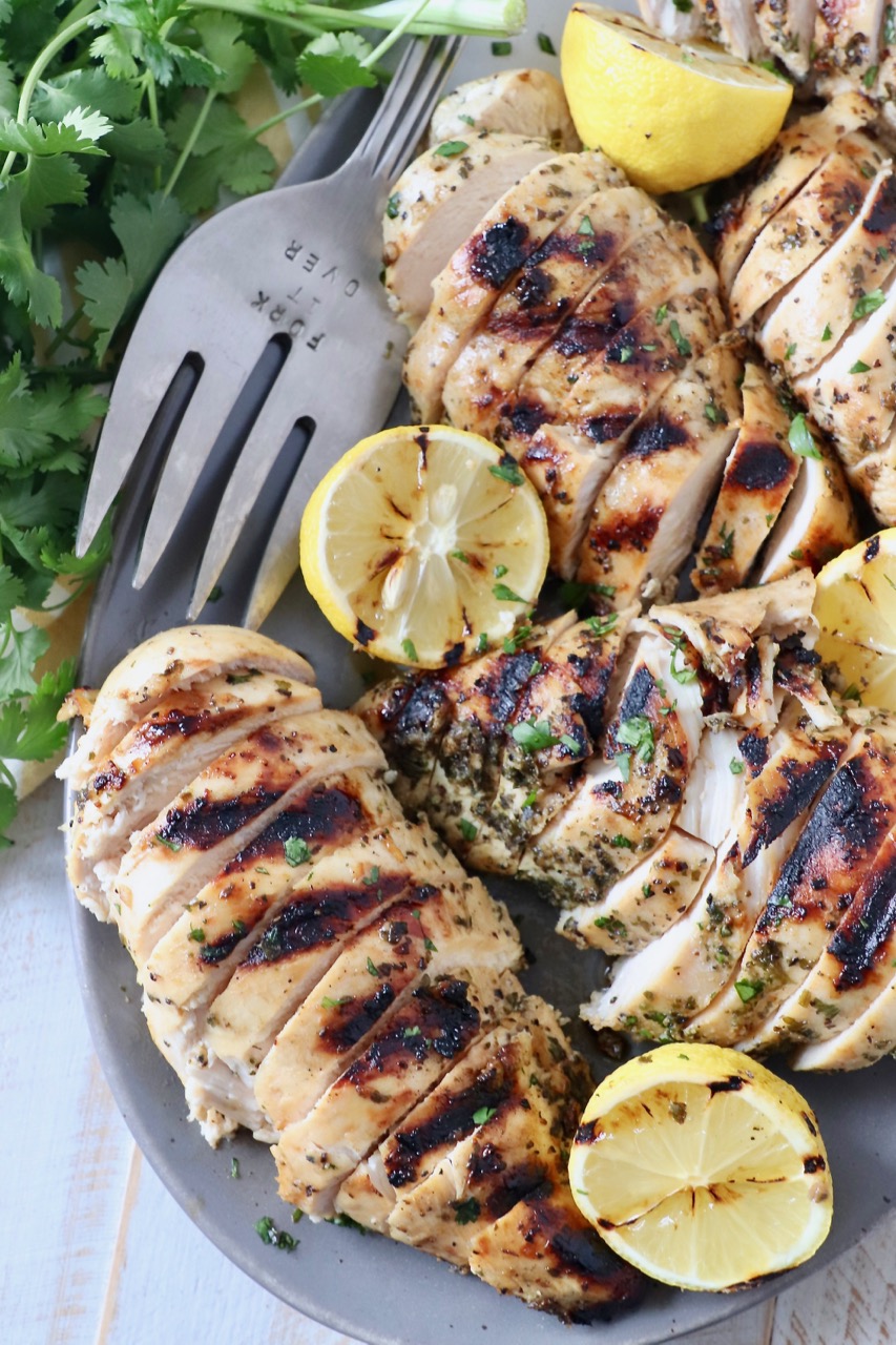 grilled chicken on plate with grilled lemons