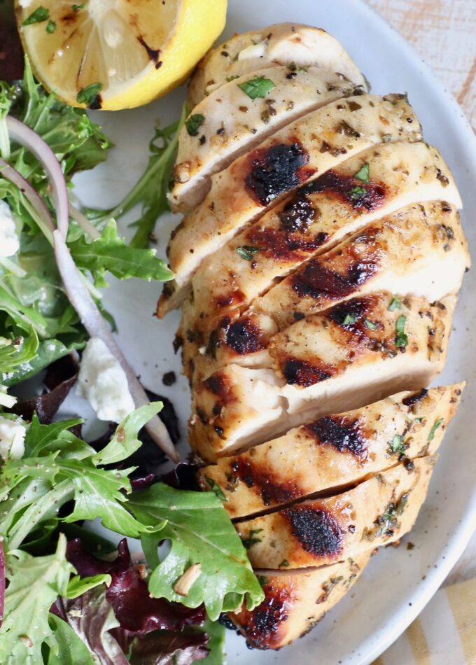 grilled sliced chicken on plate with salad