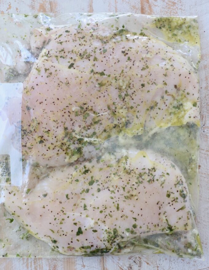chicken breasts marinating in a large zipper bag