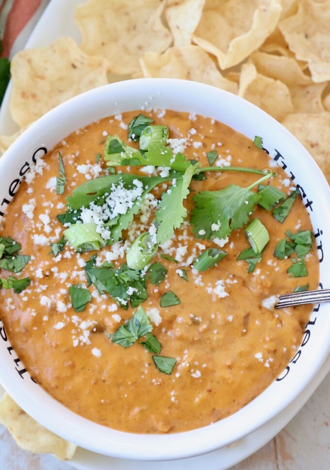 chorizo queso dip in bowl topped with fresh cilantro and green onions