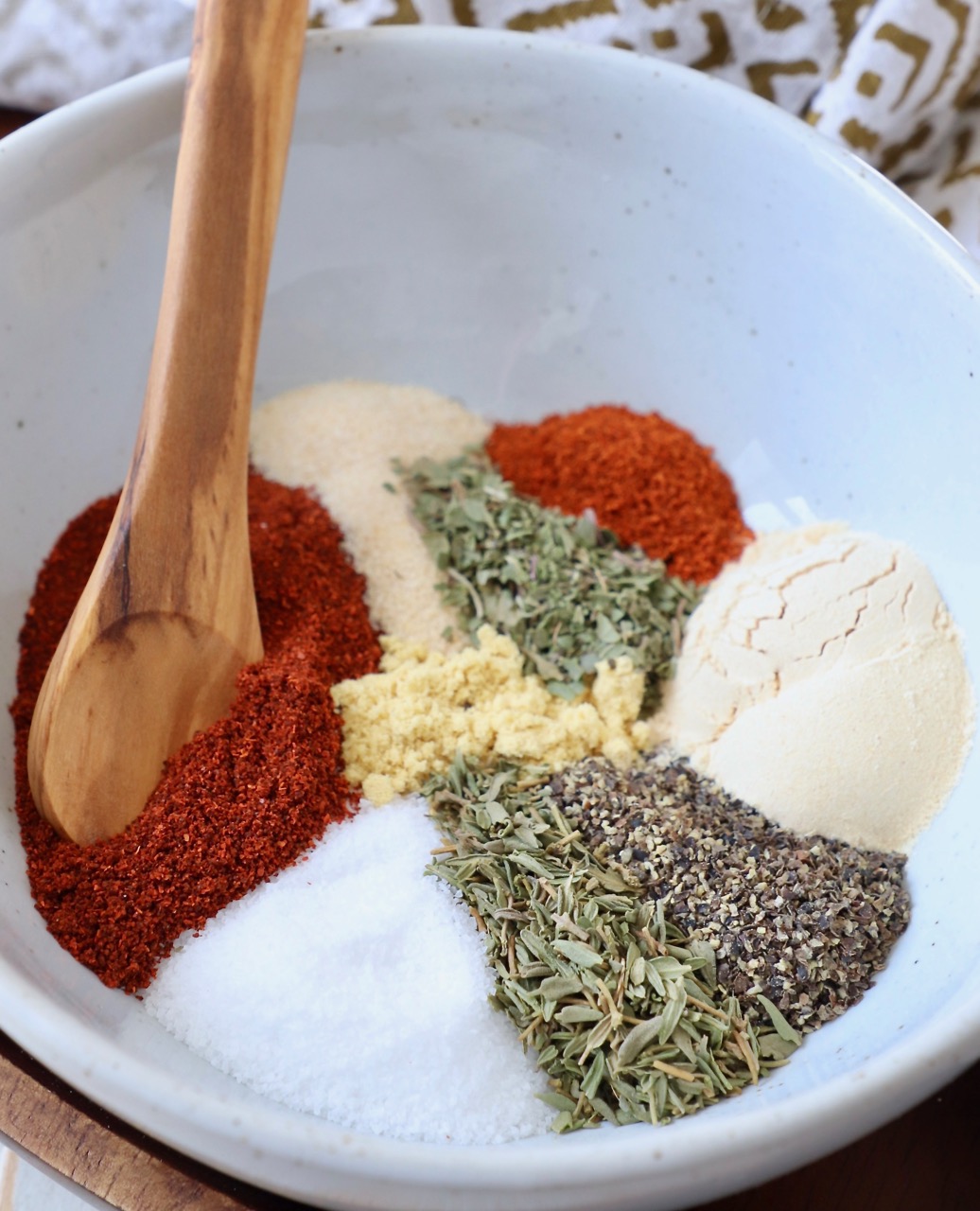 spices and herbs in bowl with wooden spoon