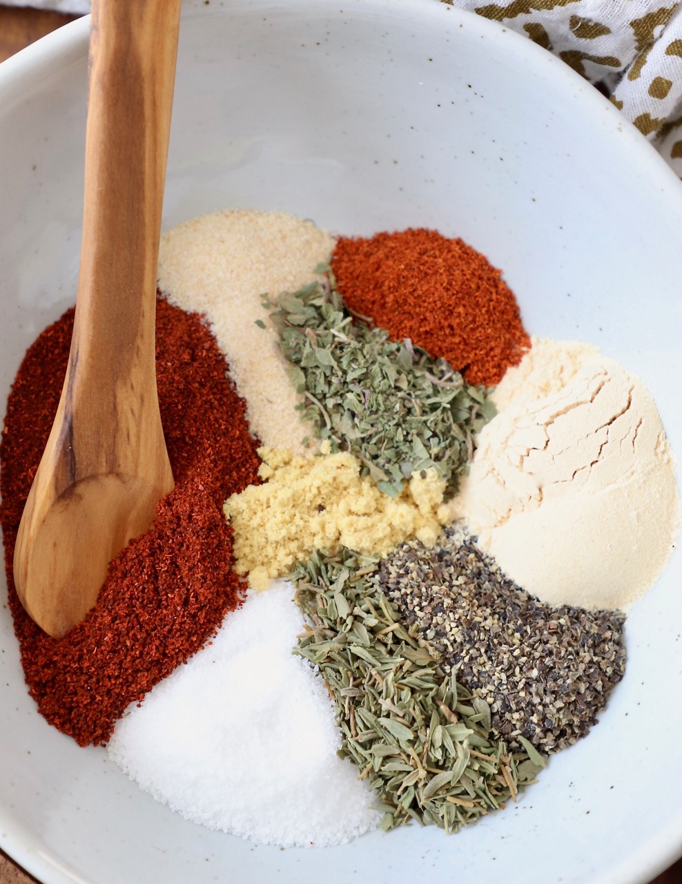 spices and herbs in bowl with wooden spoon