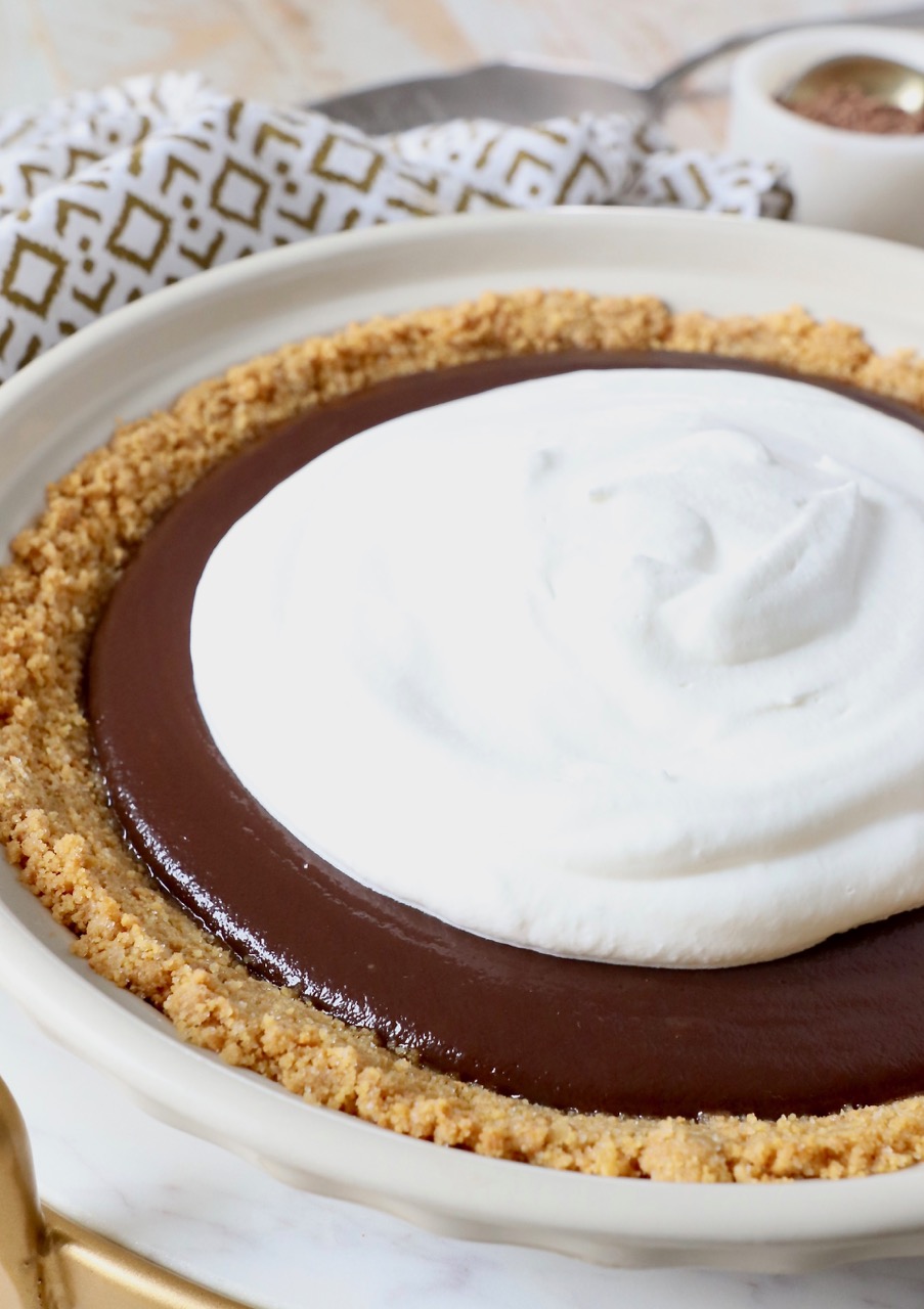 chocolate pie in pie plate topped with whipped cream