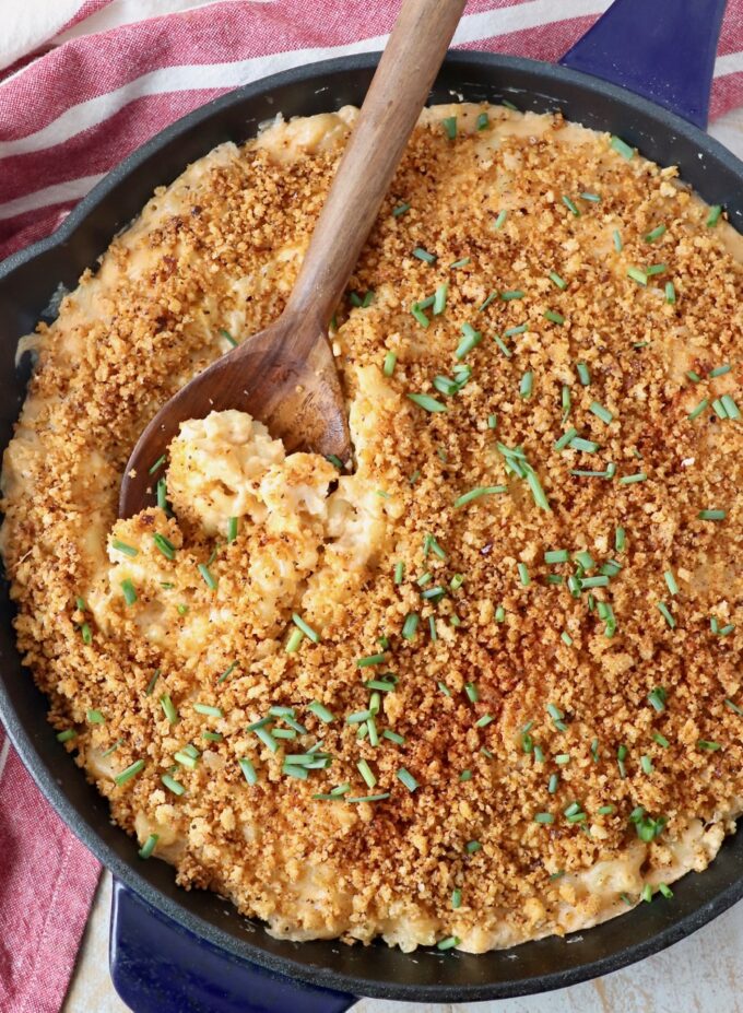 mac and cheese in large skillet with wooden serving spoon