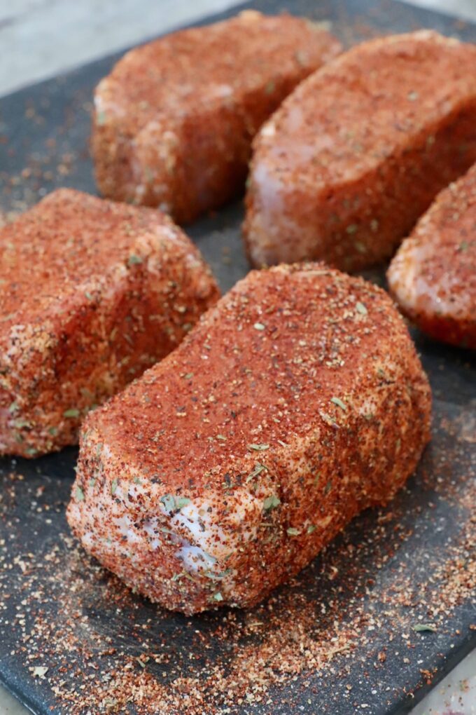 seasoned pork chops on a cutting board