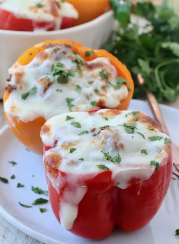 stuffed bell peppers on plate topped with melted cheese