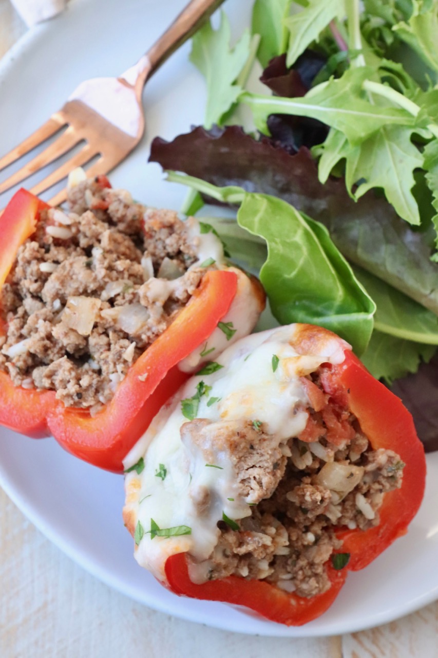 stuffed pepper cut in half on plate with salad