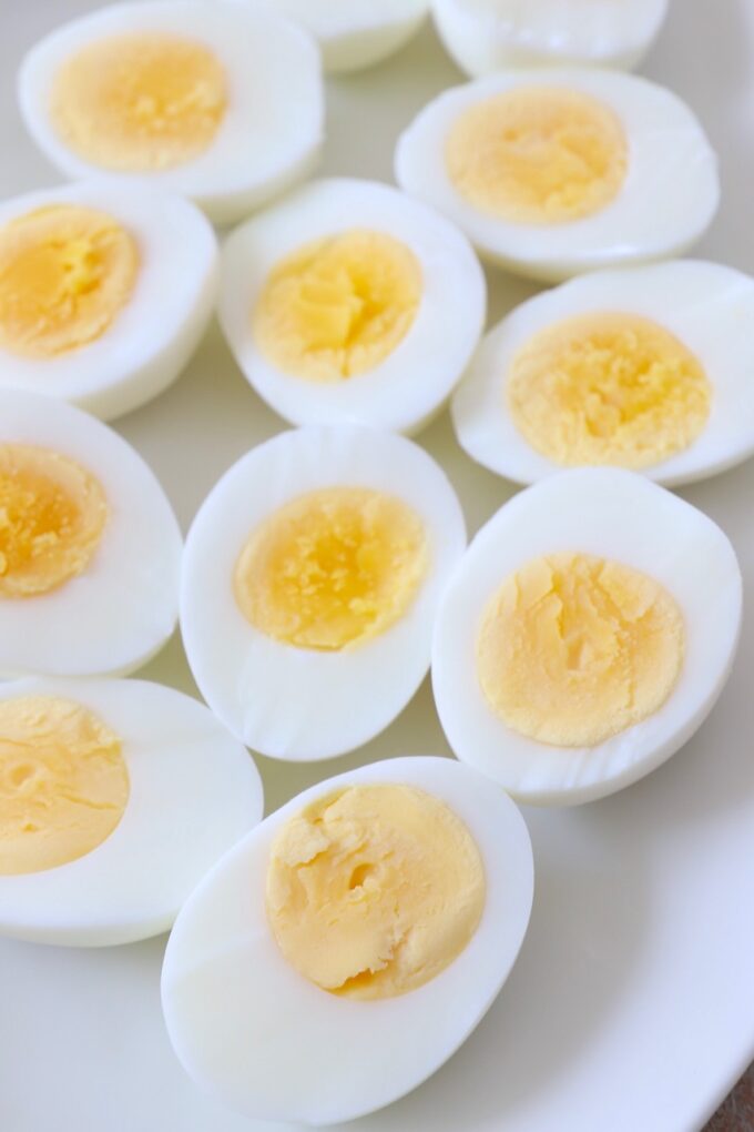 hard boiled eggs sliced in half on white plate