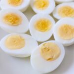 hard boiled eggs cut in half on white plate