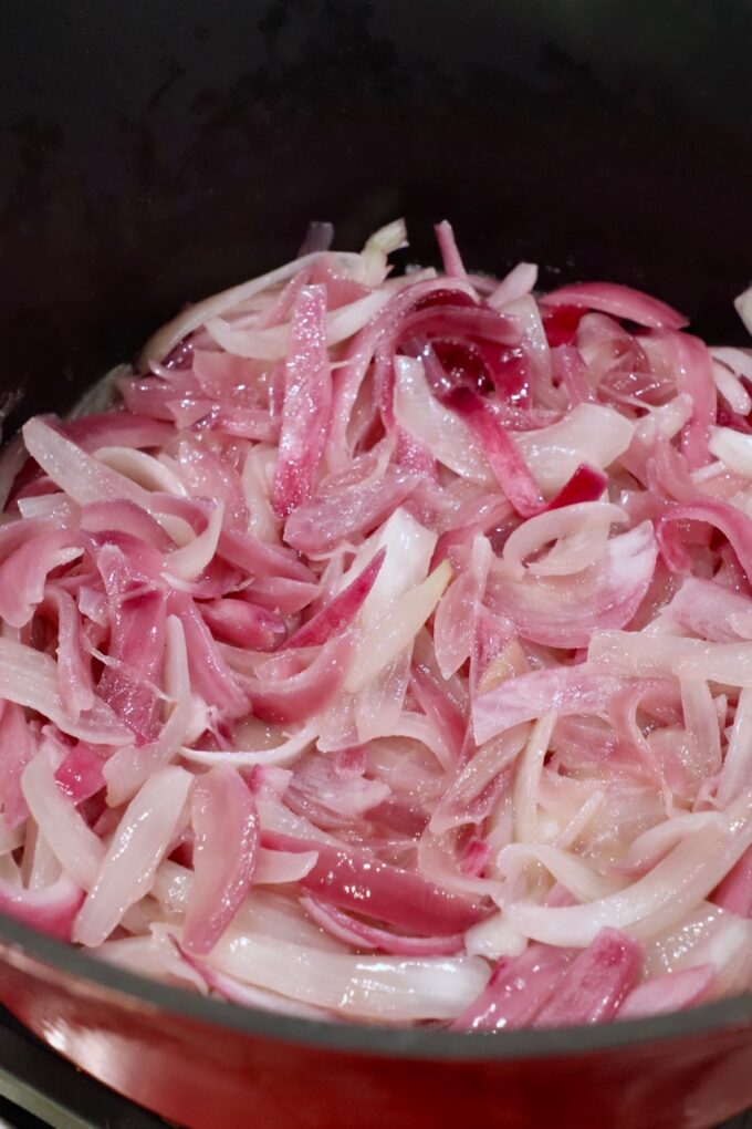 sliced onions cooking in pot on stove