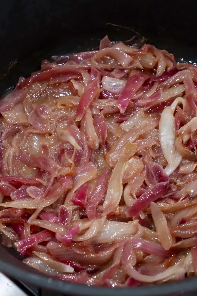 sliced onions caramelizing in pot on stove