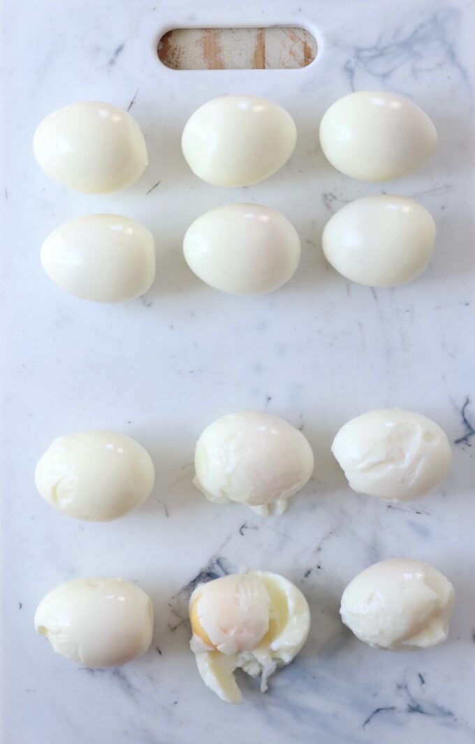 peeled hard boiled eggs on cutting board