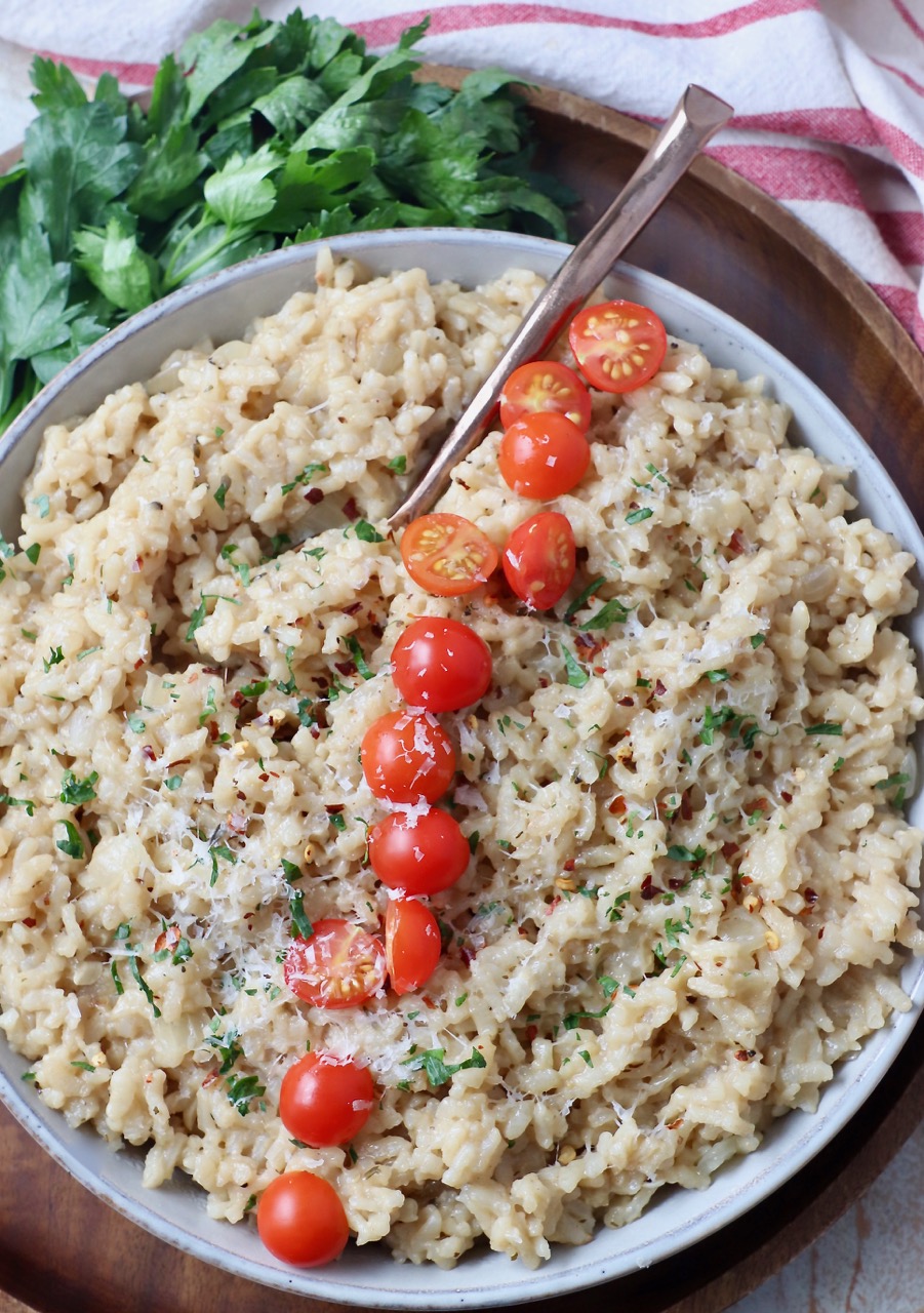 risotto in bowl topped with halved cherry tomatoes