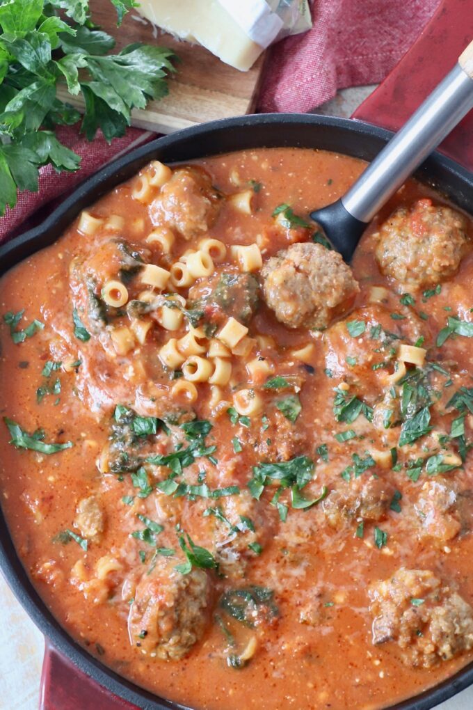 meatball soup in saucepan with serving spoon