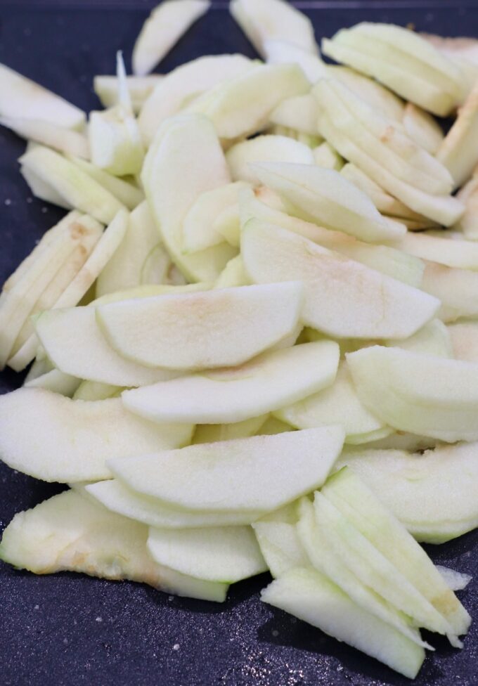 thinly sliced apples on cutting board
