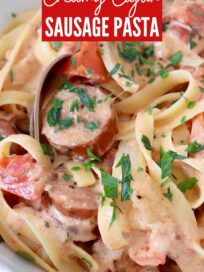 cooked pasta tossed with sausage and creamy cajun sauce in bowl with fork