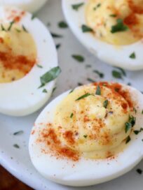 deviled eggs on plate topped with fresh chopped parsley