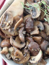 sauteed mushrooms in bowl with wooden spoon