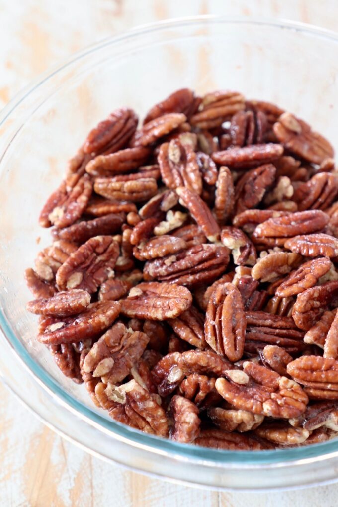 pecans coated in egg white in glass bowl