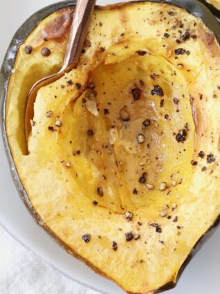 roasted half of acorn squash on plate with fork