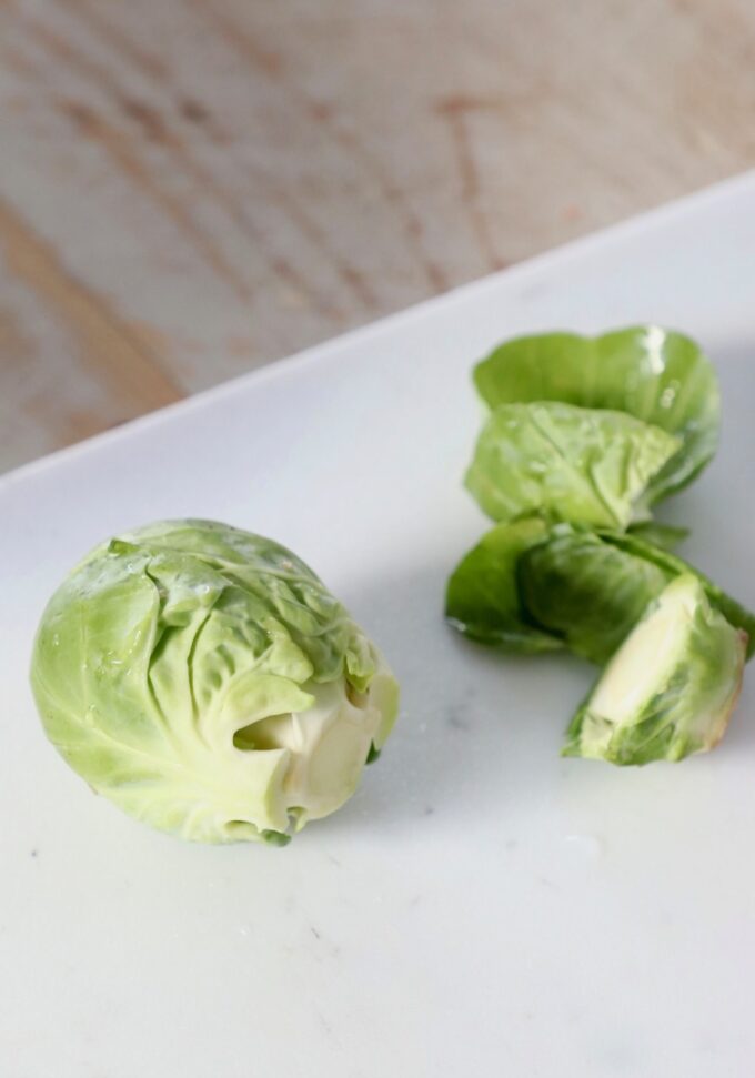 brussel sprout on cutting board with the leaves and stem removed