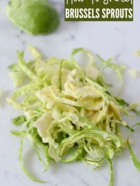 shredded brussels sprouts on white cutting board