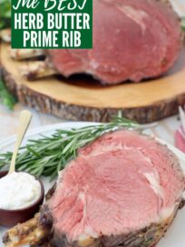 slice of prime rib with the bone on plate with fresh rosemary sprigs
