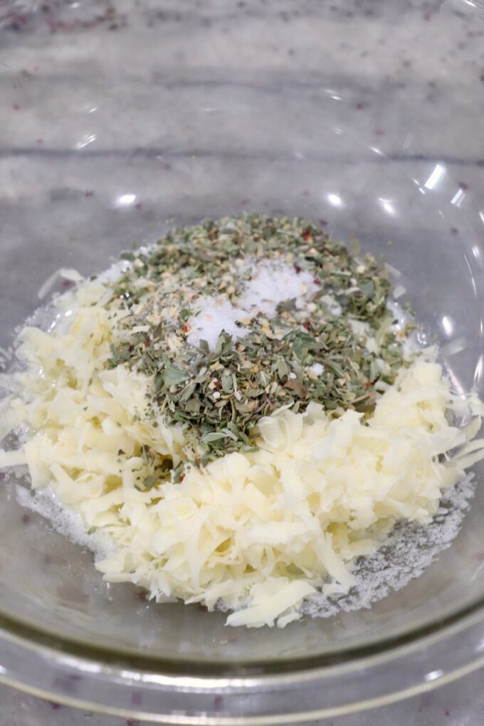 shredded cheese, herbs and butter in glass bowl