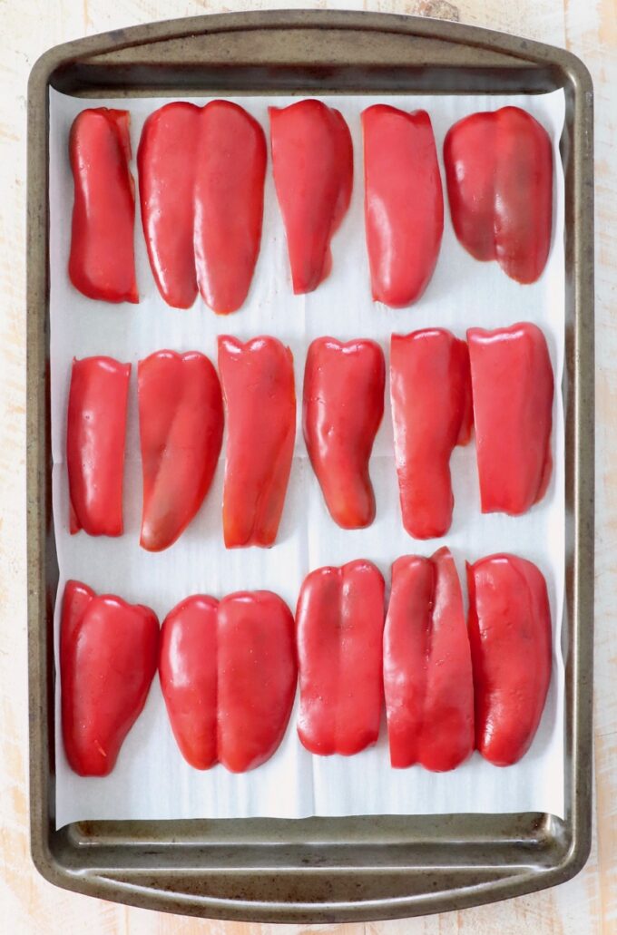 slices of red bell pepper on parchment lined baking sheet