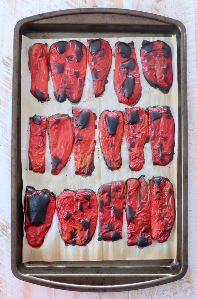 roasted red pepper slices on parchment lined baking sheet