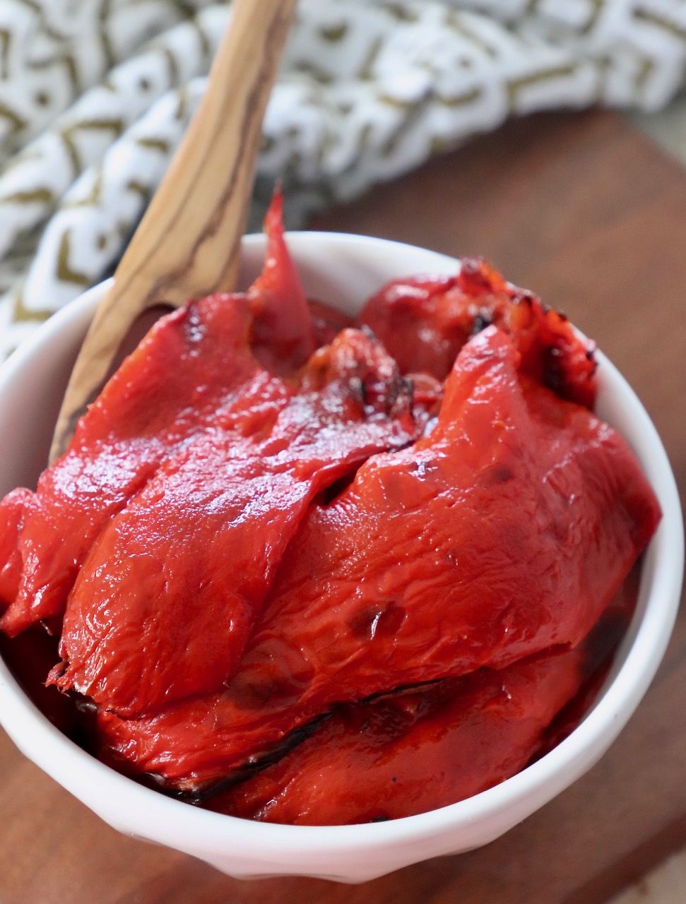 roasted red peppers in bowl with wooden fork