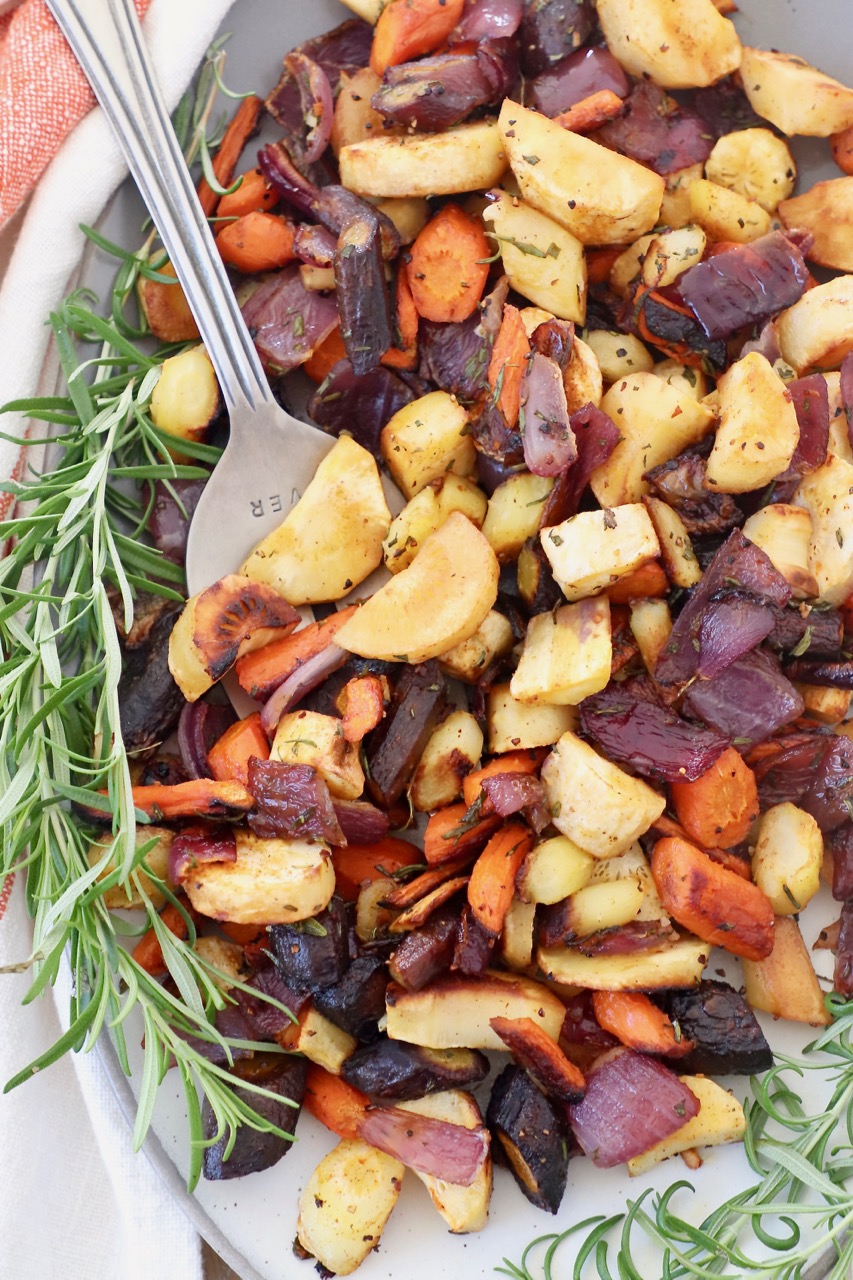 roasted vegetables on plate with serving fork and fresh rosemary sprigs