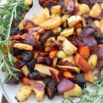 roasted carrots parsnips and onions on plate with rosemary
