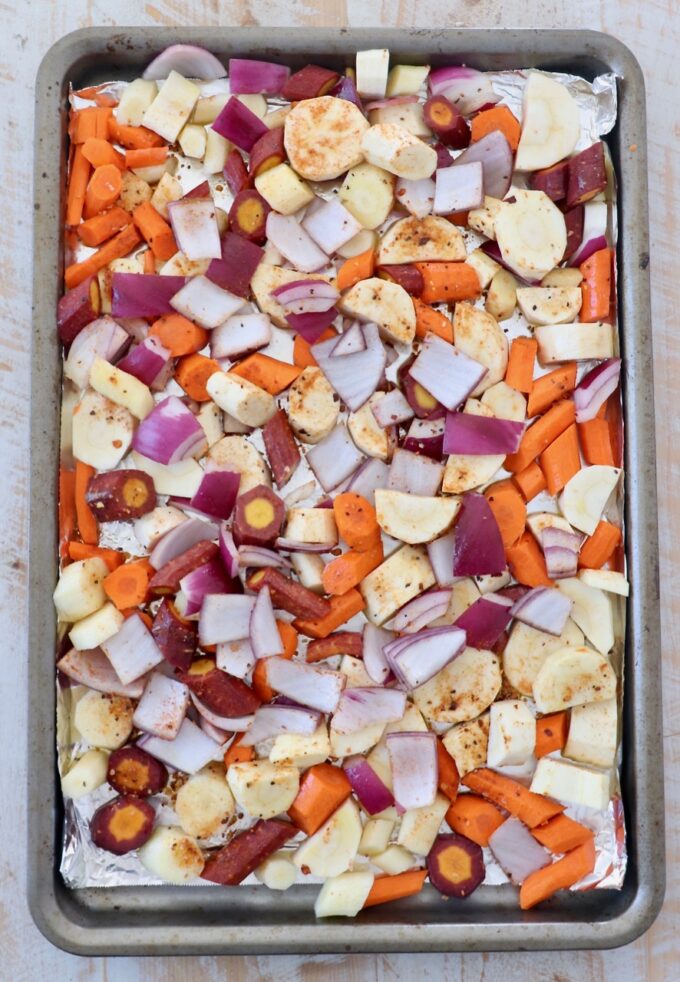 uncooked diced vegetables on parchment lined baking sheet