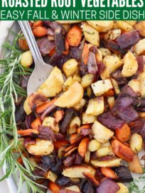 roasted root vegetables on plate with large serving fork and fresh rosemary