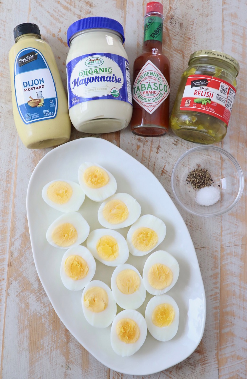 ingredients for deviled eggs on white wood board