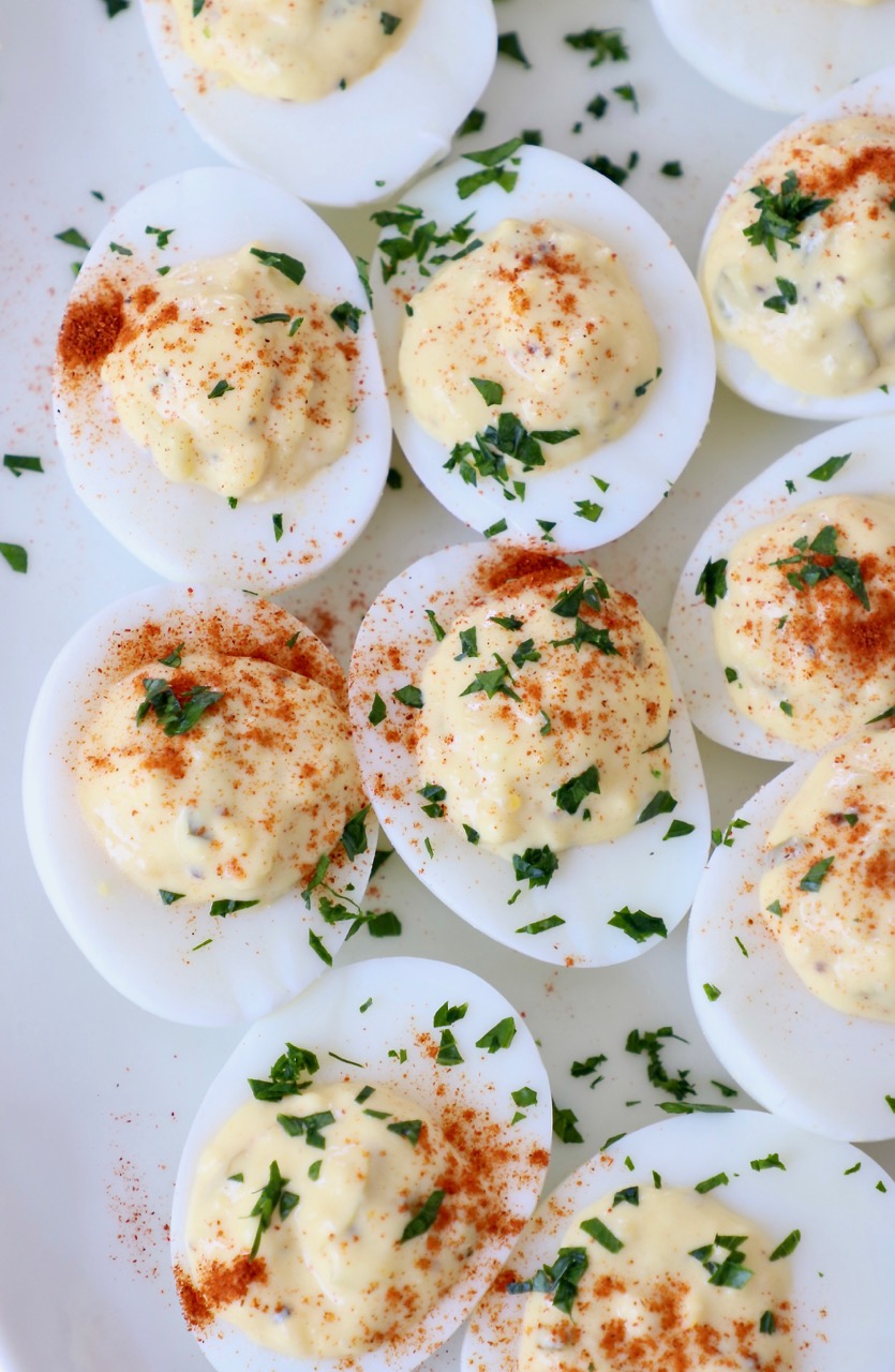prepared deviled eggs with relish on plate topped with fresh chopped parsley